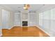 Cozy living room featuring a fireplace, built-in bookshelves, and hardwood flooring at 4418 Coventry Row Ct, Charlotte, NC 28270