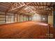 The interior of the metal barn reveals a spacious area with a robust wooden beam infrastructure at 4979 Plateau Rd, Vale, NC 28168