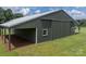Exterior view of a metal barn, featuring a large sliding door and an open sided carport area at 4979 Plateau Rd, Vale, NC 28168