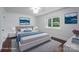 Bright bedroom with modern decor, including a mountain painting, plush bed, and a large window with a view at 4979 Plateau Rd, Vale, NC 28168