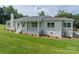 Beautiful white brick home featuring well-manicured landscaping and a covered front porch at 4979 Plateau Rd, Vale, NC 28168