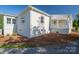 Backyard view of a renovated white brick home with new landscaping and a charming covered porch at 4979 Plateau Rd, Vale, NC 28168