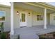 Close up of the front porch with stylish exterior lighting and a classic white front door at 4979 Plateau Rd, Vale, NC 28168