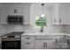 Bright, modern kitchen features white cabinets, stainless appliances, and a farmhouse sink at 4979 Plateau Rd, Vale, NC 28168