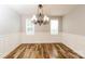 Elegant dining room with decorative chandelier, wainscoting, and beautiful wood floors at 4989 Post Oak Ln, Rock Hill, SC 29732