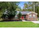 Inviting brick home features a well-maintained lawn, mature landscaping and a welcoming red front door at 4989 Post Oak Ln, Rock Hill, SC 29732