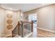Bright hallway with wood-look flooring, black metal railings, and wall decor leading into a living room at 5380 Pembrey Dr # Lot 26, Denver, NC 28037
