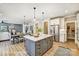 Open kitchen with stainless steel appliances, island with bar seating, and seamless flow to dining and living areas at 5380 Pembrey Dr # Lot 26, Denver, NC 28037