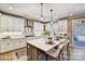 Modern kitchen with white cabinets, marble backsplash, stainless steel appliances, and large island with bar seating at 5380 Pembrey Dr # Lot 26, Denver, NC 28037