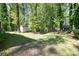 Large backyard with mature trees and green grass at 5623 Eastbrook Rd, Charlotte, NC 28215