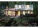 Traditional brick home with a gambrel roof, shuttered windows, and a well-manicured lawn with flowering bushes at 5623 Eastbrook Rd, Charlotte, NC 28215