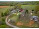 Aerial view of the property showing the home, outbuildings, fields, and surrounding countryside at 589 Lippard Farm Rd, Statesville, NC 28625