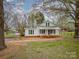 Charming, white, one-story home with a metal roof, brick accents, and inviting front porch at 589 Lippard Farm Rd, Statesville, NC 28625