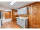 Updated kitchen showcases knotty pine walls, granite countertops, and stainless steel appliances at 589 Lippard Farm Rd, Statesville, NC 28625