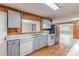 Rustic kitchen with stainless appliances, gray cabinets, and an open view to the living room at 589 Lippard Farm Rd, Statesville, NC 28625