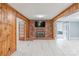 Comfortable living room features a brick fireplace, knotty pine walls, and updated floors at 589 Lippard Farm Rd, Statesville, NC 28625