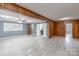 Bright living room boasts updated vinyl floors, a ceiling fan, and knotty pine accents at 589 Lippard Farm Rd, Statesville, NC 28625
