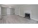 Spacious living room with gray walls, light wood floors, and a decorative fireplace at 589 Lippard Farm Rd, Statesville, NC 28625