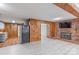Spacious living room with knotty pine paneling, brick fireplace, and updated flooring at 589 Lippard Farm Rd, Statesville, NC 28625
