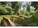 Beautiful backyard with wooden bridge over creek and a shed in a private, wooded area at 6008 Corkstone Dr, Mint Hill, NC 28227