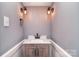 Bathroom vanity with a white countertop, custom wooden cabinets, and custom sconces at 6008 Corkstone Dr, Mint Hill, NC 28227
