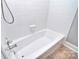 A bright white bathtub and shower combination features matching white tile at 6008 Corkstone Dr, Mint Hill, NC 28227