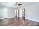 A spacious bedroom is furnished with dark wood floors and a lighted ceiling fan at 6008 Corkstone Dr, Mint Hill, NC 28227