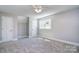 A spacious bedroom is furnished with grey carpet and a lighted ceiling fan at 6008 Corkstone Dr, Mint Hill, NC 28227