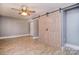 Bedroom featuring wood-look floors, ceiling fan, and unique sliding barn door at 6008 Corkstone Dr, Mint Hill, NC 28227