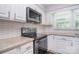Bright kitchen with stainless steel appliances, white cabinetry and subway tile backsplash at 6008 Corkstone Dr, Mint Hill, NC 28227
