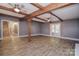 Open-concept living room with exposed beams, wood floors, and access to stairs and patio at 6008 Corkstone Dr, Mint Hill, NC 28227