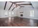 Open living room with high ceilings, wood beams, brick fireplace, and hardwood floors at 6008 Corkstone Dr, Mint Hill, NC 28227