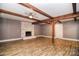 Large living room with exposed wood beams, brick fireplace, and wood laminate flooring at 6008 Corkstone Dr, Mint Hill, NC 28227