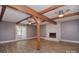 Spacious living room features exposed beams, brick fireplace, and double doors to patio at 6008 Corkstone Dr, Mint Hill, NC 28227