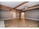 Living room featuring wood laminate flooring, exposed beams, ceiling fan, and natural light at 6008 Corkstone Dr, Mint Hill, NC 28227