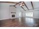 Spacious living room featuring vaulted ceilings, wood beams, a brick fireplace, and hardwood floors at 6008 Corkstone Dr, Mint Hill, NC 28227