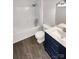 Clean bathroom with sleek blue vanity, modern fixtures, and a tub-shower combination at 704 Georgie St, Troutman, NC 28166