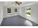 Bright and spacious bedroom featuring soft carpeting, a tray ceiling with fan, and plenty of natural light at 704 Georgie St, Troutman, NC 28166