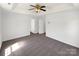 Generously sized bedroom featuring neutral carpeting, tray ceiling with ceiling fan, and access to doors and closets at 704 Georgie St, Troutman, NC 28166