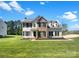 Charming two-story home featuring a brick and siding exterior, black shutters, and a well-manicured lawn at 704 Georgie St, Troutman, NC 28166