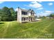 Inviting two-story home featuring a manicured front lawn, well-placed landscaping, and charming architectural details at 704 Georgie St, Troutman, NC 28166