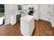 Bright kitchen with white cabinets, stainless steel appliances, island and wood floors at 704 Georgie St, Troutman, NC 28166