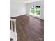 Bright, airy living room featuring wood-look flooring and two large windows offering ample natural light and a view of the lawn at 704 Georgie St, Troutman, NC 28166