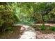 Landscaped backyard path with mature trees and greenery at 7230 Ridge Lane Rd, Charlotte, NC 28262