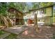 Backyard view showcasing the home's screened porch, covered parking, patio, and lush greenery at 7230 Ridge Lane Rd, Charlotte, NC 28262