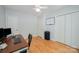 Well-lit bedroom featuring hardwood floors, modern desk, and closet storage at 7230 Ridge Lane Rd, Charlotte, NC 28262