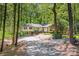 Charming home with gravel driveway surrounded by mature trees and natural landscaping at 7230 Ridge Lane Rd, Charlotte, NC 28262