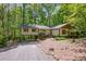 Charming home with a gravel driveway and colorful exterior features, nestled among lush trees at 7230 Ridge Lane Rd, Charlotte, NC 28262