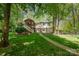 Rear exterior of the home with screened porch, covered parking, and a lush yard at 7230 Ridge Lane Rd, Charlotte, NC 28262