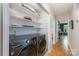 Hallway featuring front-load washer/dryer, shelving, and views of the dining area at 7230 Ridge Lane Rd, Charlotte, NC 28262